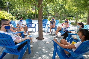 Group of students sitting in a circle outside.